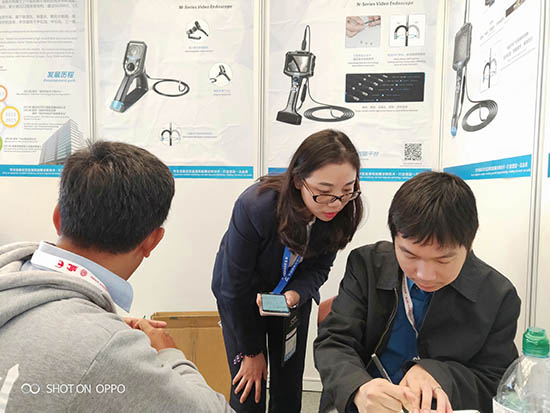 亞泰光電展臺(tái)前，公司內(nèi)窺鏡工程師與客戶親密交談為